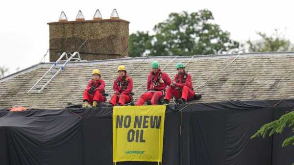 Greenpeace demonstrators drape UK prime minister’s house in black to protest oil expansion