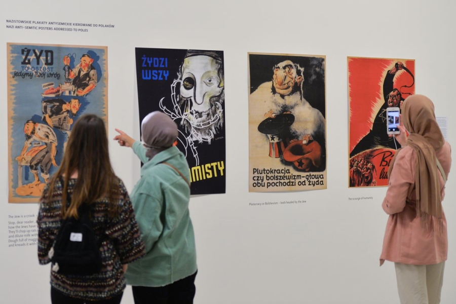 Visitors to a museum look at an exhibit on antisemitic propaganda.