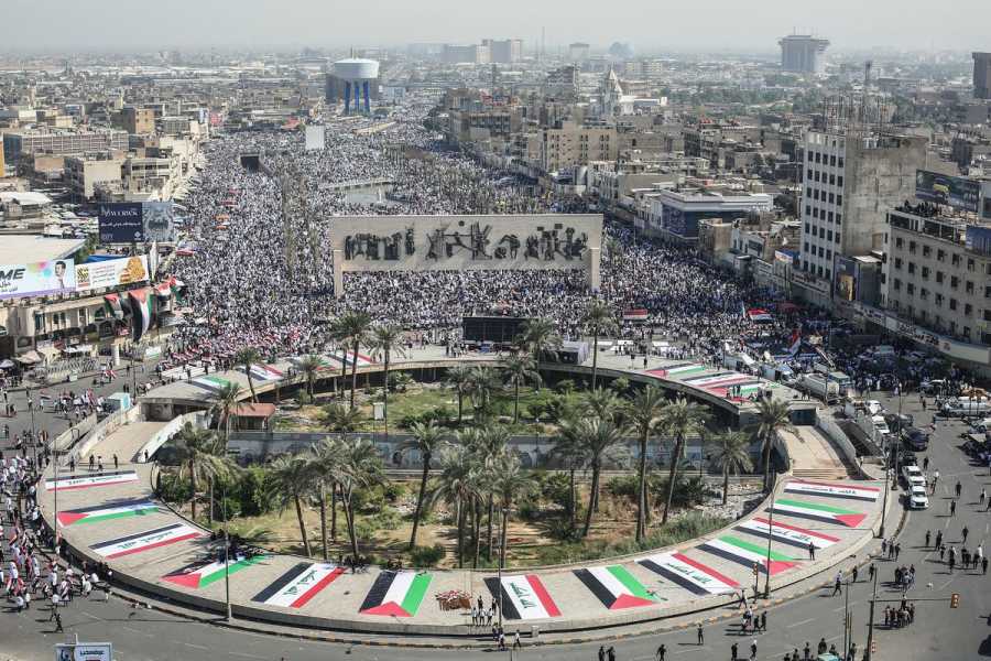 In the central park in Baghdad’s Tahrir Square, Iraqi and Palestinian flags are laid out in a circle as thousands of protesters march in the square and surrounding streets. 