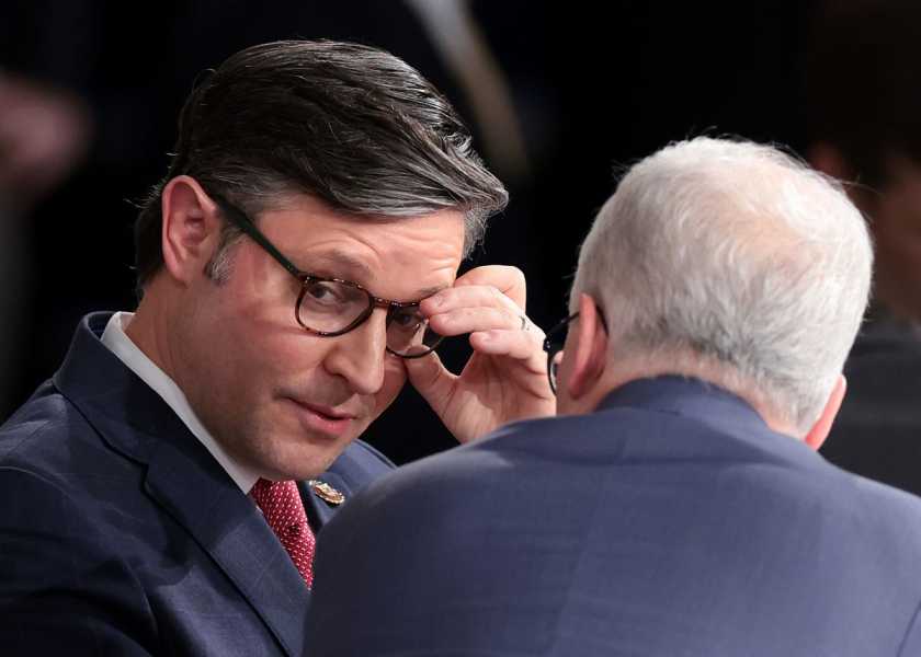 Johnson touches his glasses as he and McHenry engage in conversation.