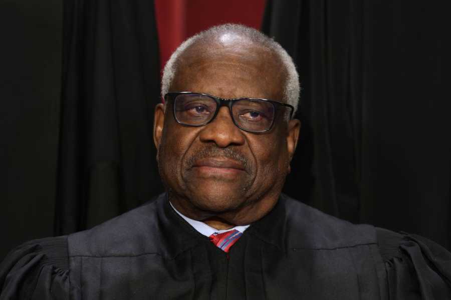 Justice Clarence Thomas in black robes, staring ahead.