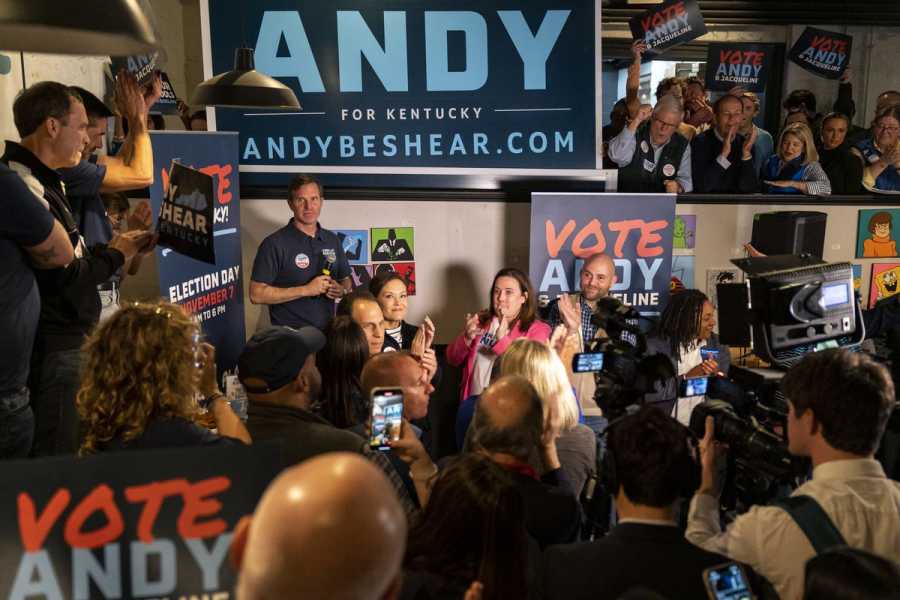 Beshear onstage surrounded by supporters and signs reading Vote Andy.