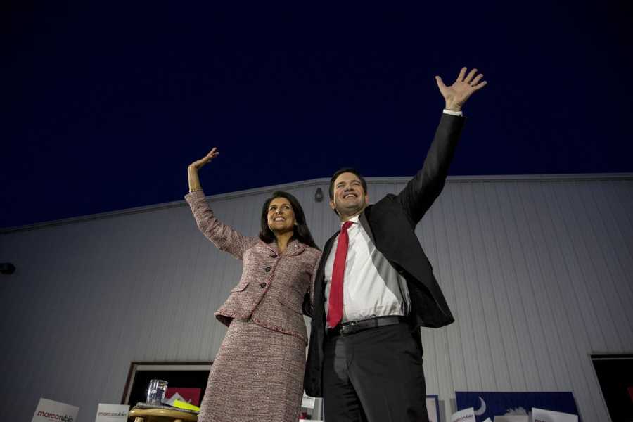 Haley and Rubio stand arm in arm waving. 