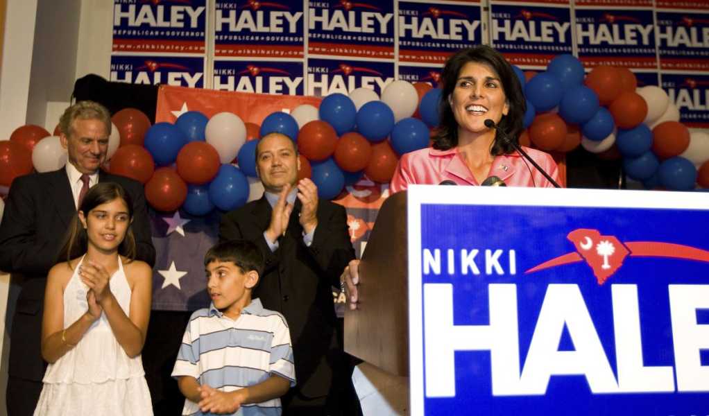 Nikki Haley stands onstage, with her family standing to the left of her.