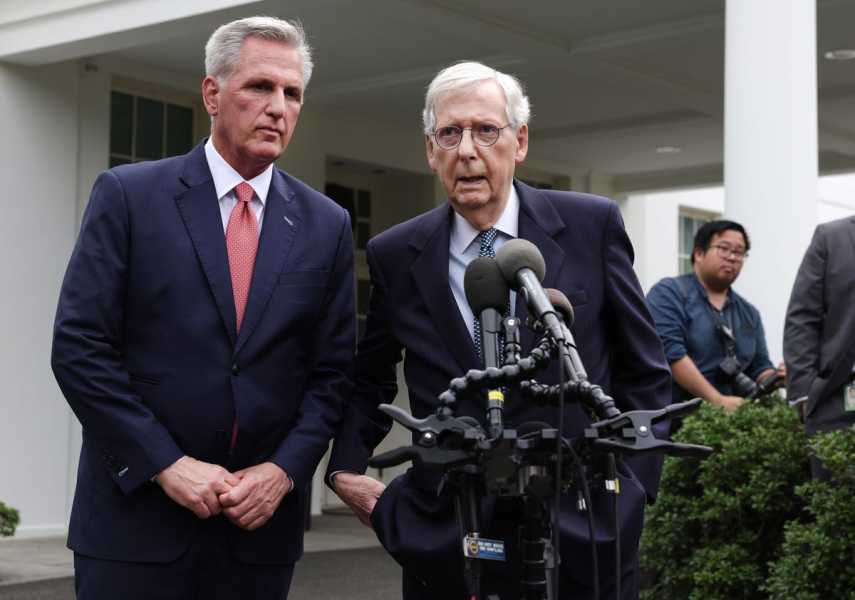 Kevin McCarthy and Mitch McConnel stand at a podium with microphones outside the White House.