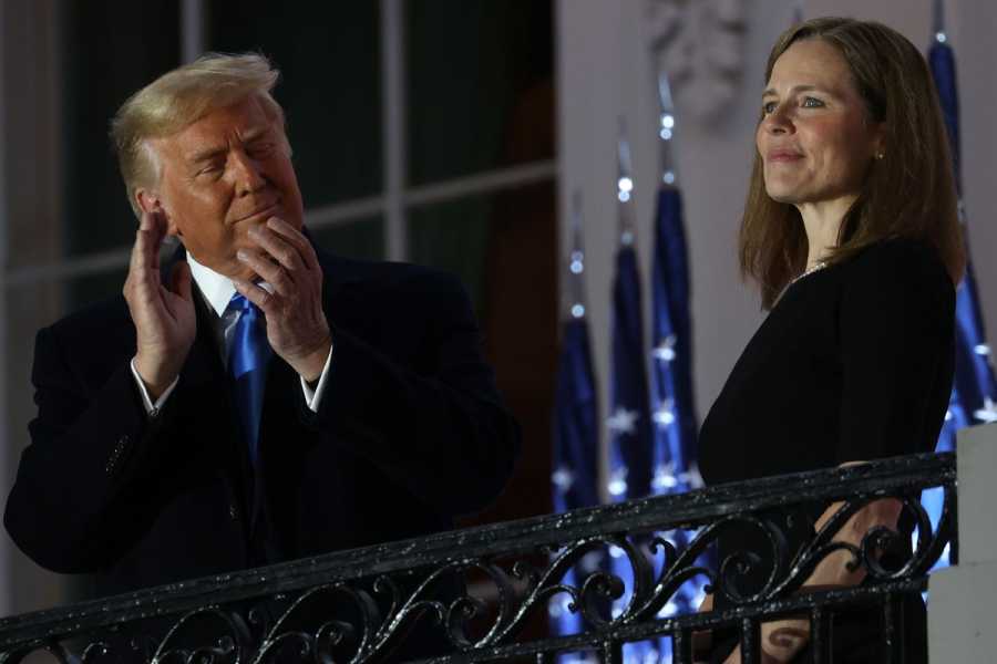 Donald Trump claps as he looks on at Amy Coney Barrett.