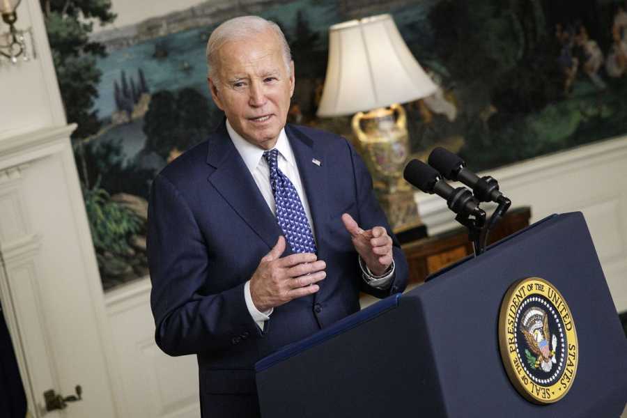 Biden speaks at a lectern at the White House.