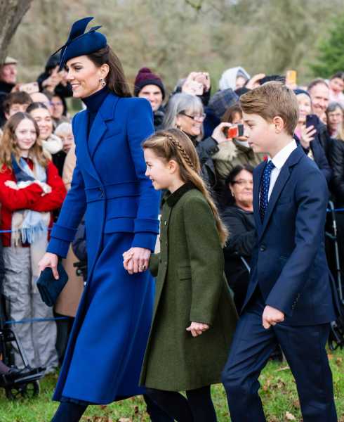 Kate Middleton walks hand in hand with her daughter. Her older son accompanies them through a throng of people.