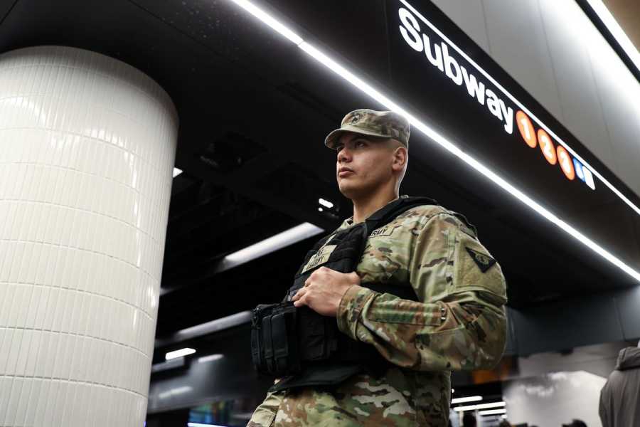 A National Guard with a gun standing in the New York subway.