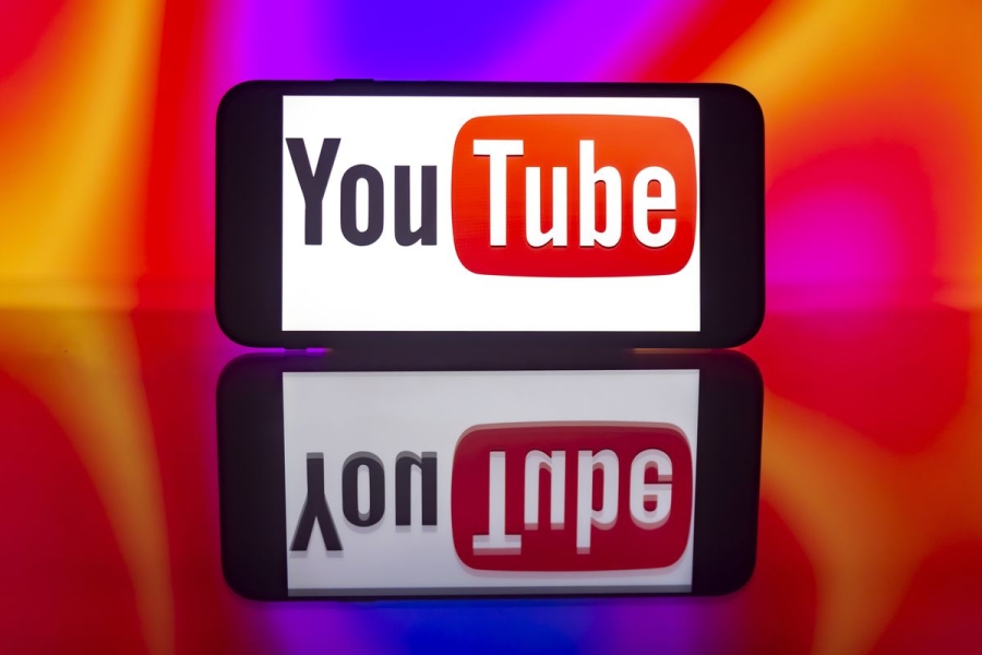 A photo illustration of the YouTube logo is seen on a smartphone screen.