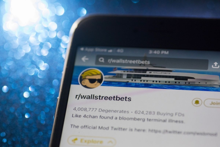 A laptop screen shows the site Reddit and the page for Wall Street Bets. 