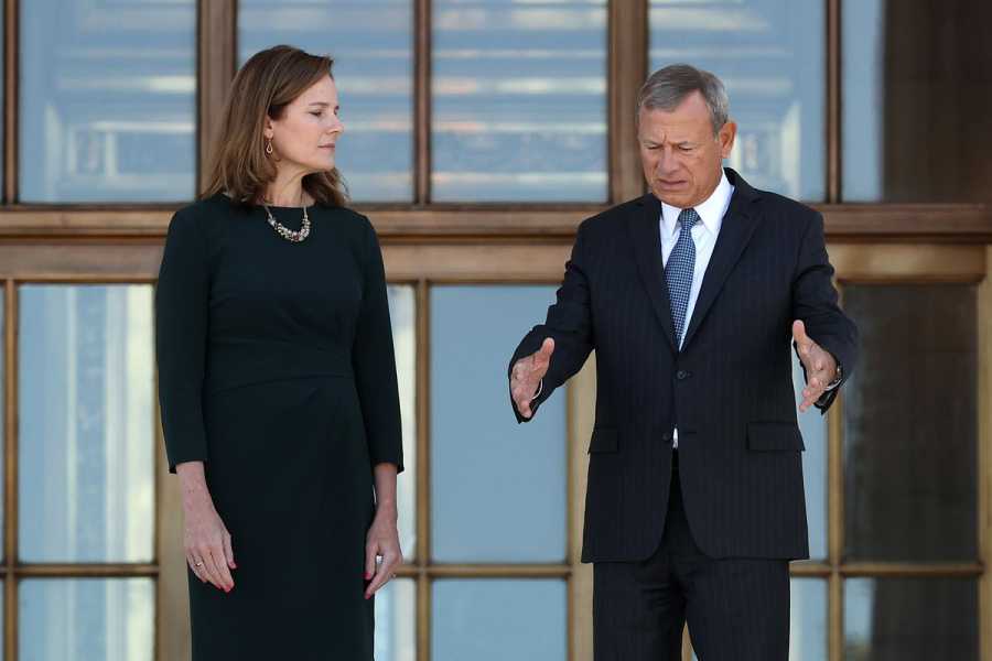 Associate Justice Amy Coney Barrett standing outside the west side of the Supreme Court building with Chief Justice John Roberts.