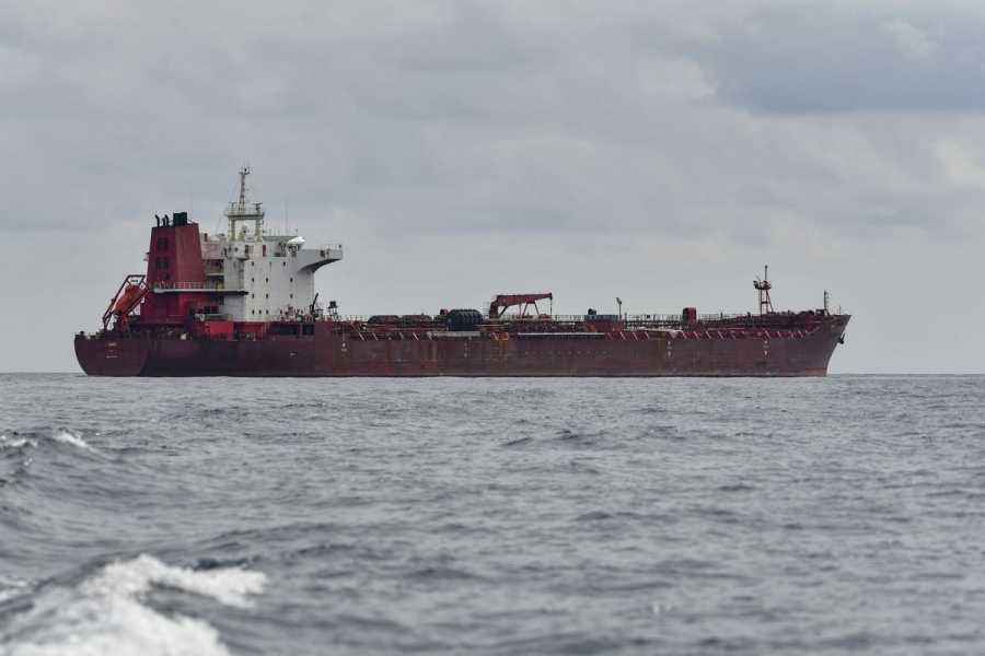A red oil tanker at sea. 