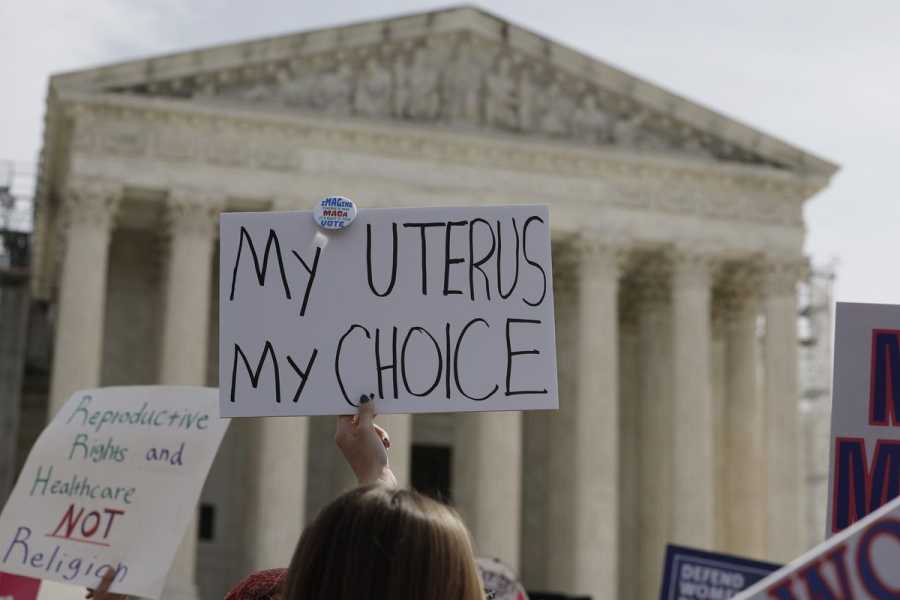 A sign is raised outside the Supreme Court building that says “My uterus my choice.”