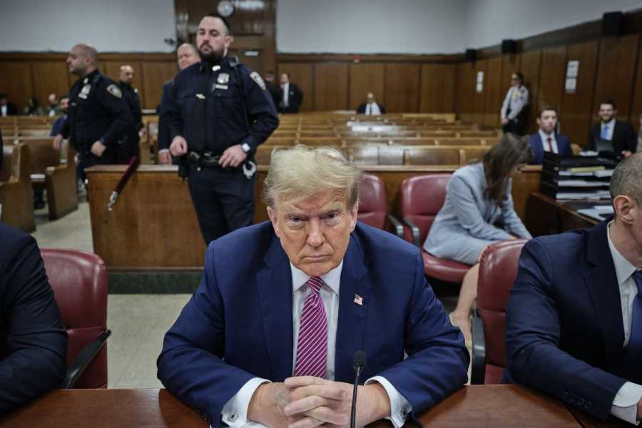 Trump sitting at a table in a courtroom.