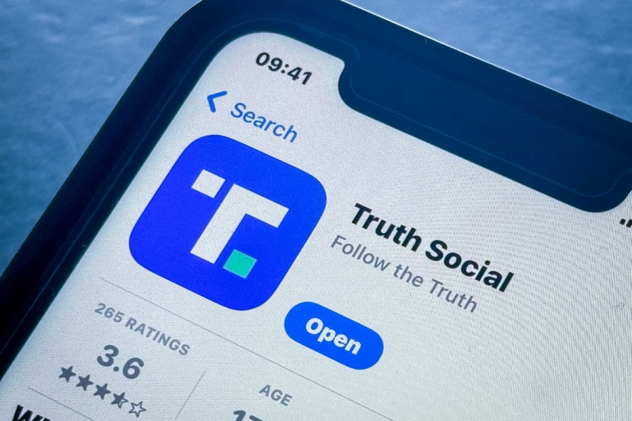 A smartphone screen shows the logo of the Truth Social app.