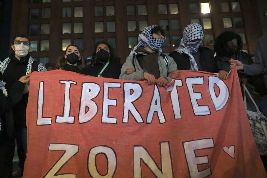 Pro-Palestinian protesters holding a sign that says “Liberated Zone” in New York.