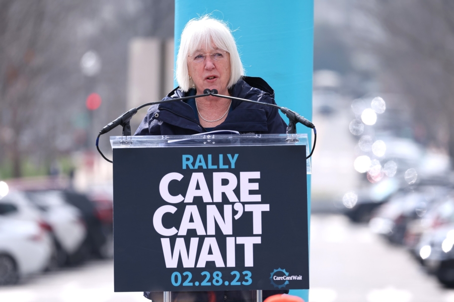 Sena. Patty Murray speaks outside to a crowd in front of a rally sign that says “Care Can’t Wait.”