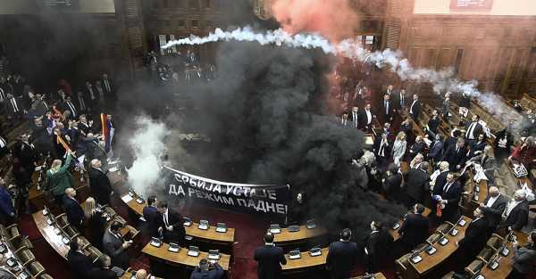 At least three Serbian MPs were injured after smoke bombs and flares were thrown into parliament