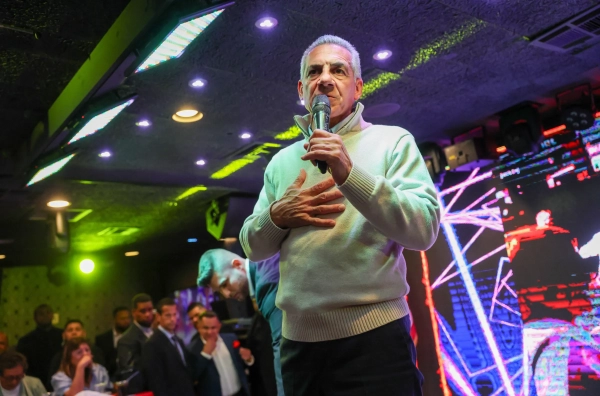 Ciattarelli speaks into a microphone at a restaurant, with people in the background